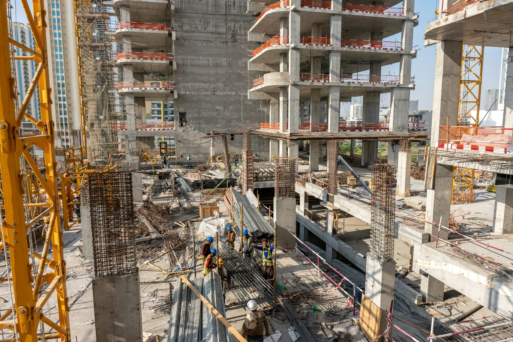 Edifício residencial em construção, com estrutura de concreto e guindaste